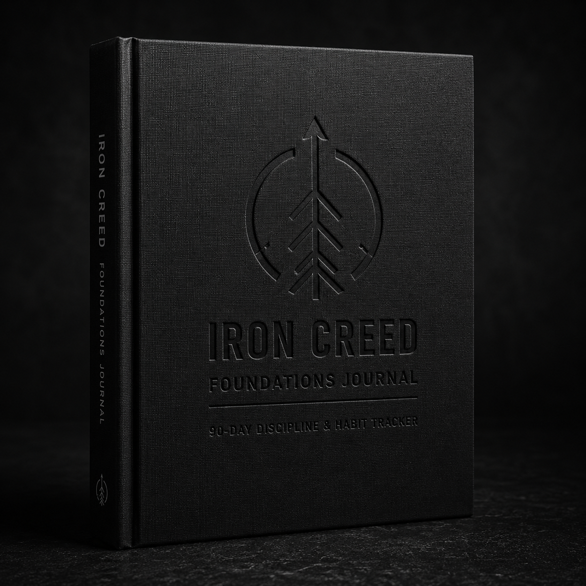 Iron Creed Foundations Journal cover mockup with embossed logo and title on a dark stone surface
